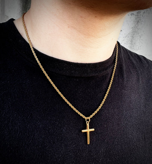 Model wearing a 20 inch 18k gold rope chain with a cross pendant on it