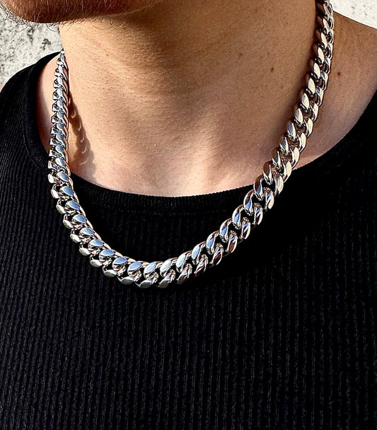 Silver 12mm miami cuban link chan around a models neck with a black shirt on 