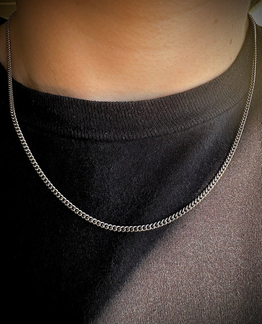 Model wearing a silver 2mm cuban chain with a black shirt 